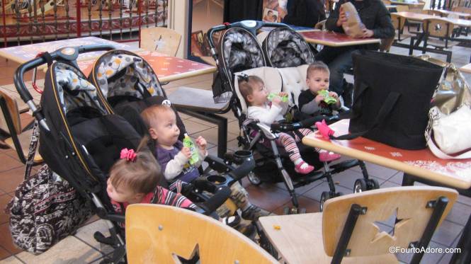 This is how you feed eight babies in a food court.  No need for strollers- simply dish out finger foods and strap sippy cups onto the stroller.  I love that these strollers have three snack catch/ drink holders per stroller.